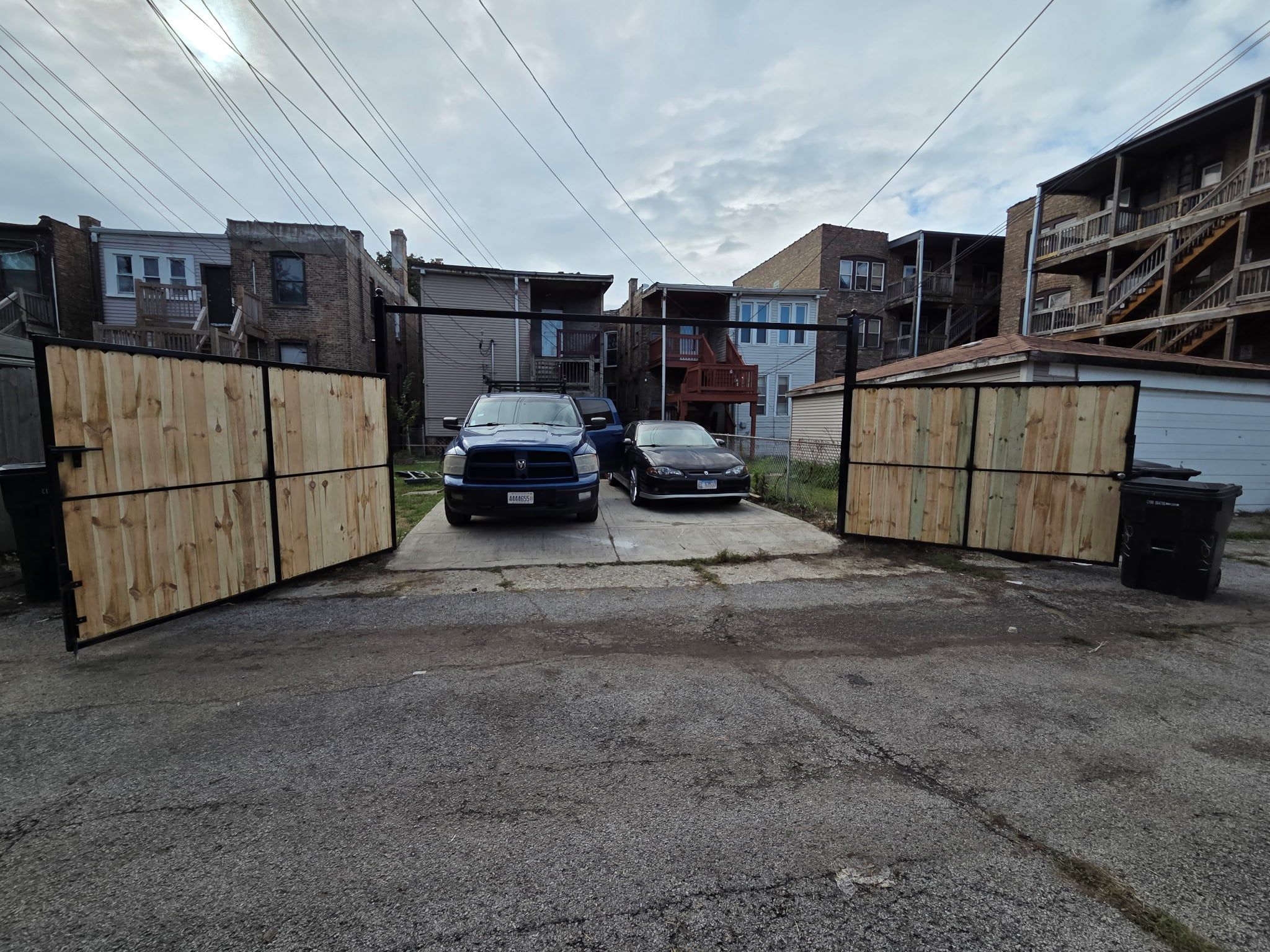 The same double gate swung open to the parking pad