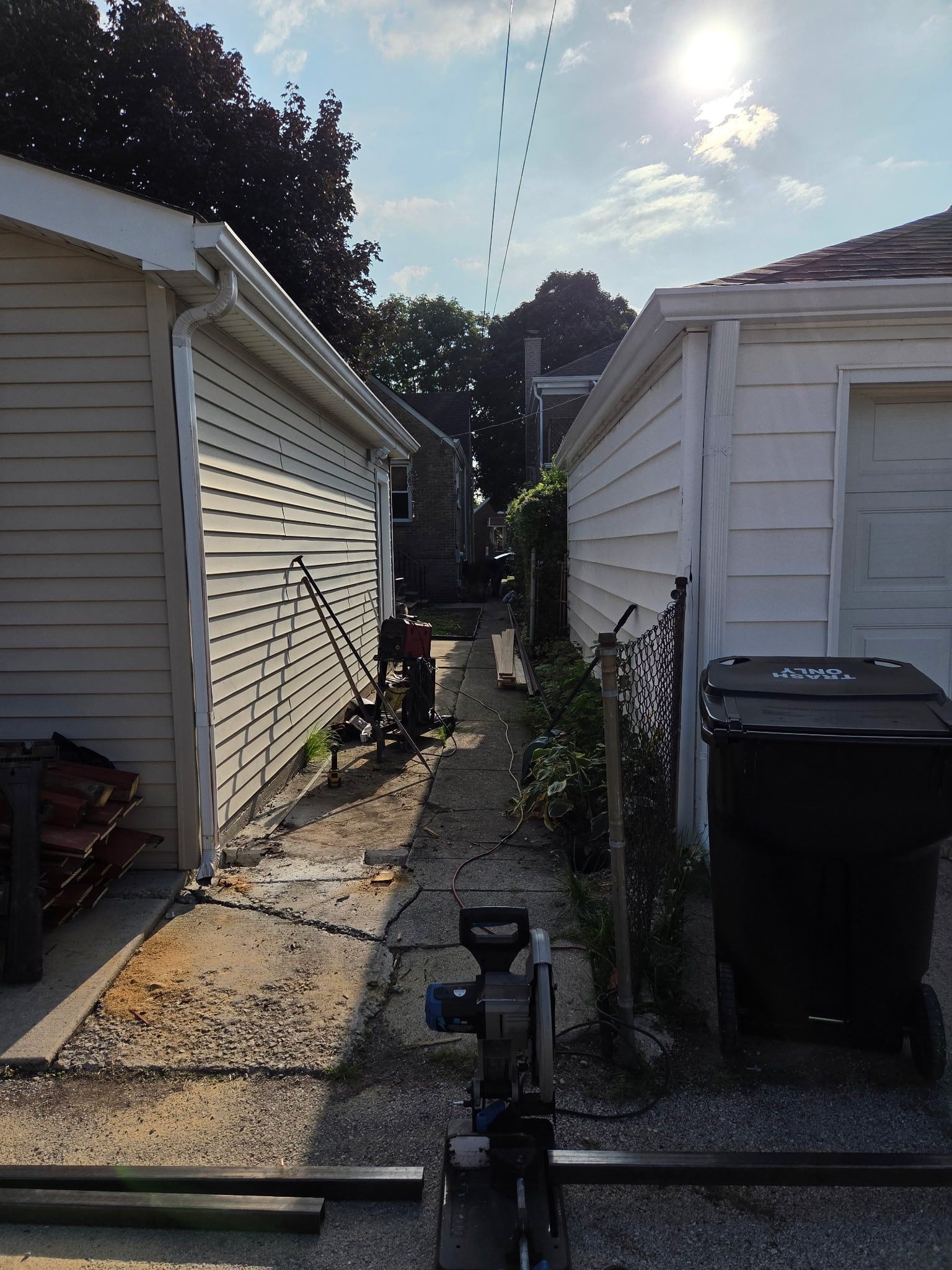 Gangway between the house and the garage cleared for the new gate, with steel posts ready