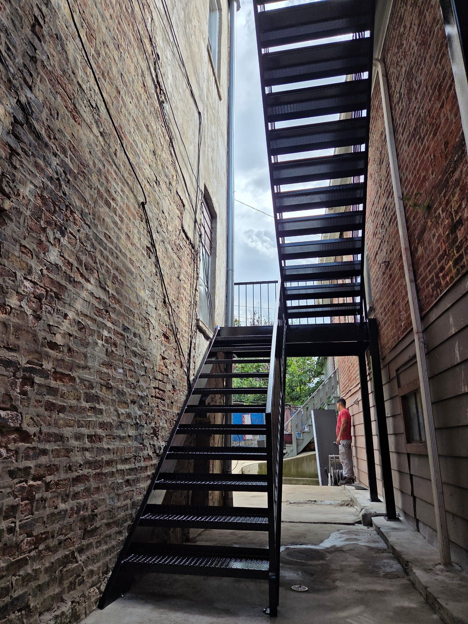 Full run of the new black steel stairs with open treads and handrails in the gangway